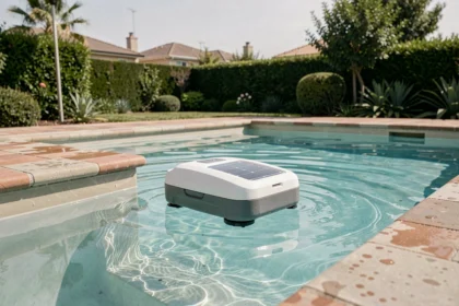 Robot nettoyeur solaire autonome glissant à la surface d'une piscine turquoise dans un jardin moderne